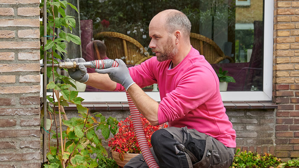 Medewerker van Essent isoleert woning dankzij spouwmuur isolatie om energie te besparen